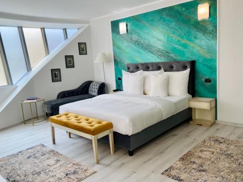 a bedroom with a king sized bed and a couch at Hotel Paradis in Cluj-Napoca