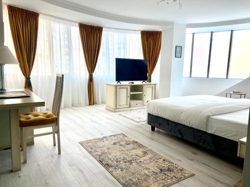 a bedroom with a bed and a desk and a television at Hotel Paradis in Cluj-Napoca