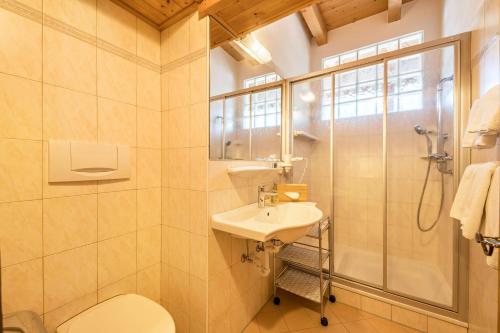 a bathroom with a toilet and a sink and a shower at Baumgartnerhof Appartment Magnolie in Lagundo