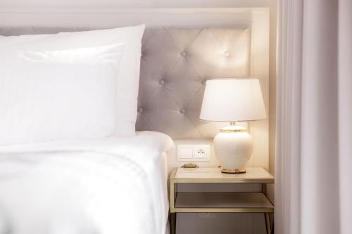 a bedroom with a bed and a lamp on a night stand at Maritime Residence in Międzyzdroje
