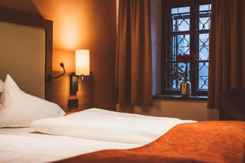 a bed in a hotel room with a window at Heritage Hotel Hallstatt in Hallstatt
