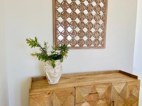 a vase sitting on top of a wooden cabinet with a plant at Tenuta Centoporte in Otranto