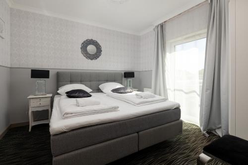 - une chambre avec un grand lit blanc et une fenêtre dans l'établissement Apartament Pięć Mórz by Renters, à Sianożęty