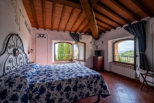 Hotel Vecchia Oliviera في مونتالشينو: غرفة نوم بسرير ونوافذ