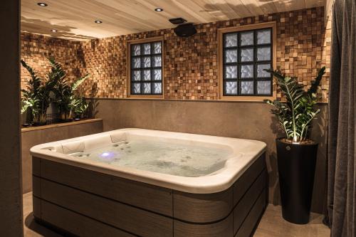 a jacuzzi tub in a room with plants at Le Domaine des Prés Verts Suites & Chambres avec Jacuzzi Privatif à Châteauneuf in Châteauneuf