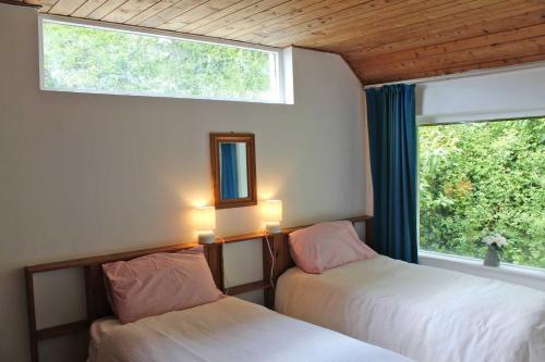 2 camas en una habitación con ventana en Wreckers Cottage en Dunmore East