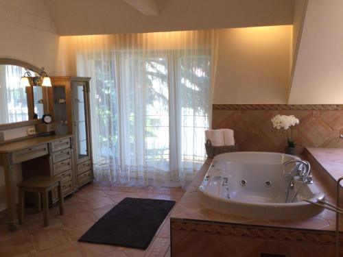 een grote badkamer met een bad en een wastafel bij Jókai Apartment in Sopron