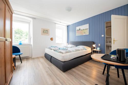 a bedroom with a bed and a desk and a table at Gästehaus Mona Lisa in Neef