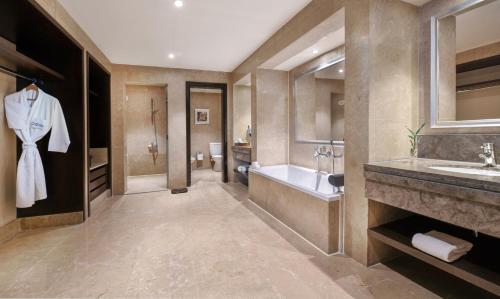 a bathroom with a tub and a sink and a bath tub at JAZ Aquamarine in Hurghada
