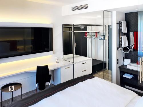 una camera con letto, scrivania e doccia di DORMERO Hotel Deggendorf a Deggendorf