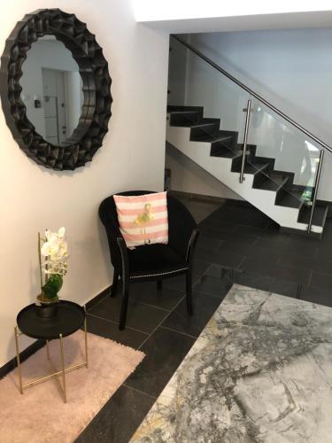 a living room with a chair and a mirror at Beside Airport in Otopeni