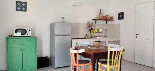 a kitchen with a table and a refrigerator at Matino Antico Borgo in Matino