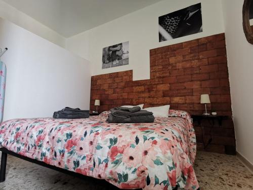 sypialnia z łóżkiem i ceglaną ścianą w obiekcie Baby House w mieście Castel di Tusa