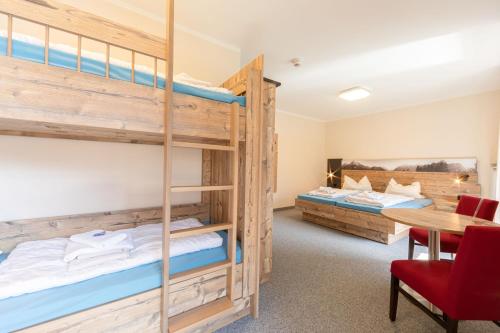 a room with two bunk beds and a desk at ALPEN EXPERIENCE - CVJM Aktivzentrum Hintersee, Jugendgästehaus in Ramsau