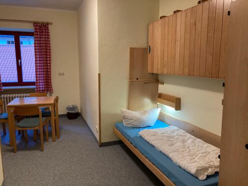 a dorm room with a bunk bed and a table at ALPEN EXPERIENCE - CVJM Aktivzentrum Hintersee, Jugendgästehaus in Ramsau
