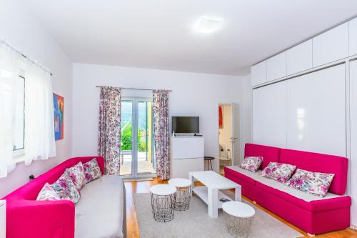 a living room with two red couches and a table at Kumbor beauty in Kumbor