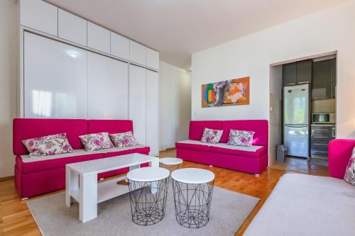 a living room with a pink couch and a table at Kumbor beauty in Kumbor