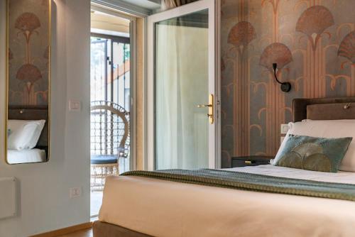 a bedroom with a bed and a door to a balcony at Relais Villa dei Gelsi & Spa in Verona