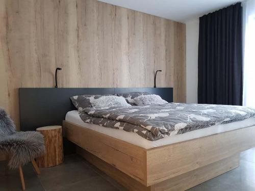 um quarto com uma cama e uma parede de madeira em Apartmán Pod Hochfichtem em Nová Pec
