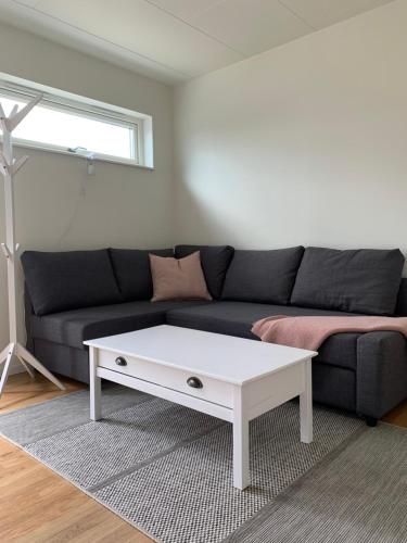 sala de estar con sofá y mesa de centro blanca en Hjalmars Väg 10 Magnarp, en Vejbystrand