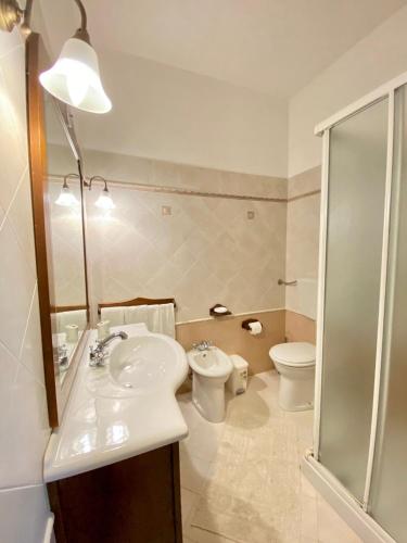 a bathroom with a sink and a toilet and a shower at Baglio Cusenza Rooms in San Vito lo Capo