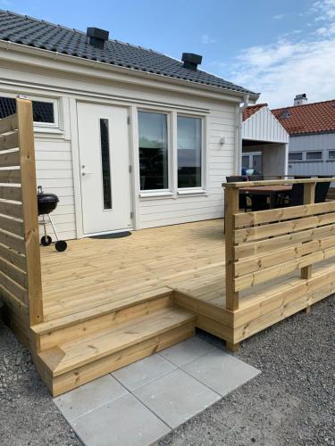 Hjalmars Väg 10 Magnarp في Vejbystrand: سطح خشبي أمام المنزل