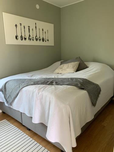 1 dormitorio con 1 cama con sábanas blancas y pared en Hjalmars Väg 10 Magnarp, en Vejbystrand