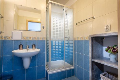a blue bathroom with a sink and a shower at Apartman SIESTA*** in Liptovský Mikuláš