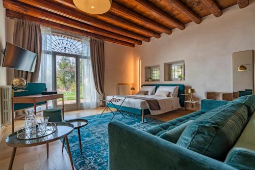 a living room with a blue couch and a bed at Relais Villa dei Gelsi & Spa in Verona