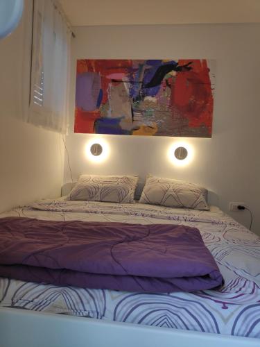 a bedroom with a bed with two pillows and a painting at Kumbor beauty in Kumbor