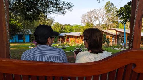 a man and a woman sitting on a bench at Cabañas Oberá in Oberá