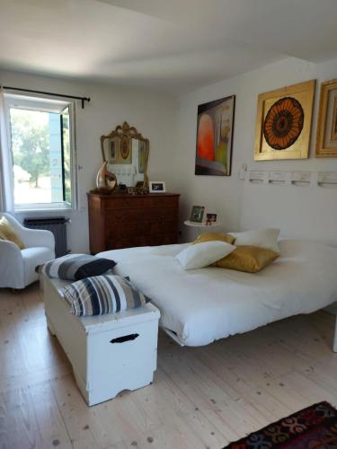 a bedroom with a large white bed and a chair at Casa sulla roggia in Lumignacco