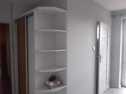 a white closet with white shelves in a room at Waldek in Jastrzębia Góra