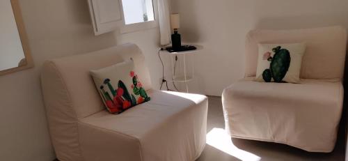 ein Wohnzimmer mit einer weißen Couch und einem Stuhl in der Unterkunft Matino Antico Borgo in Matino