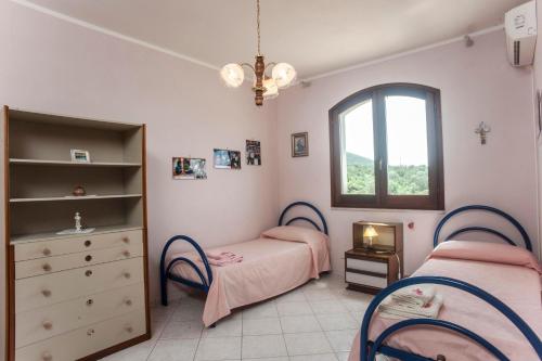 a bedroom with two beds and a window at Casa Elena in Masainas