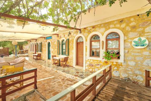 a stone house with a porch and a patio at Can Mocamp in Kas