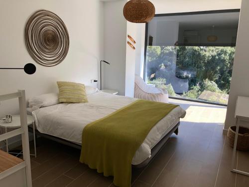a bedroom with a bed and a large window at Casa KARIAN in Tossa de Mar