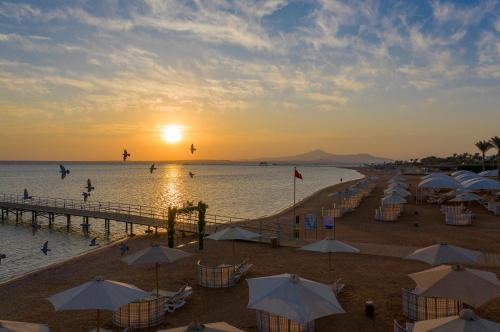 a beach filled with lots of people and umbrellas at Rixos Premium Seagate - Ultra All Inclusive in Sharm El Sheikh