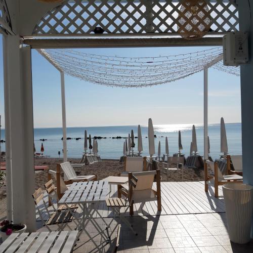 a group of chairs and umbrellas on a beach at Hotel Enzo in Porto Recanati
