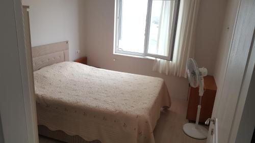 a small bedroom with a bed and a window at 1+1 furnished flat with pool in Lara