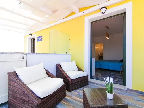 een patio met rieten stoelen en een tafel en een slaapkamer bij B&B La Torre Elite in Santa Teresa Gallura