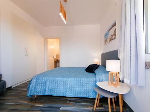 a bedroom with a blue bed and a table with two chairs at B&B La Torre Elite in Santa Teresa Gallura
