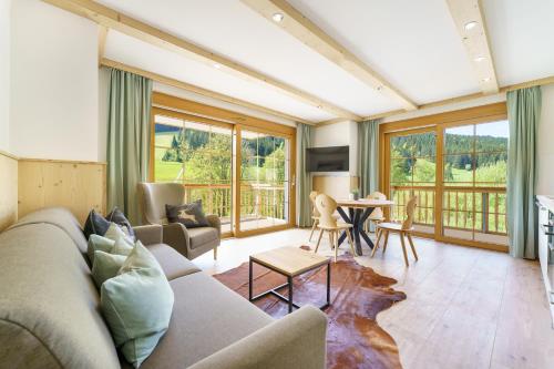 a living room with a couch and a table at SCHWARZENBACH - Apartments & Rooftop Pool in Feldberg