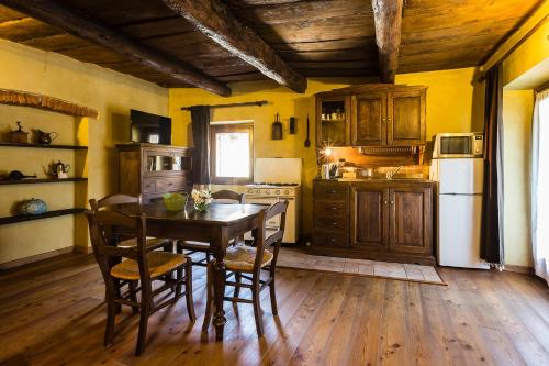 Borgo TicinoにあるRelais Dei Cesariのキッチン(テーブル、椅子、白い冷蔵庫付)
