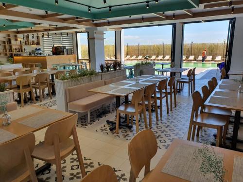 a restaurant with tables and chairs and a pool at Amber Hotel Albania in Spille
