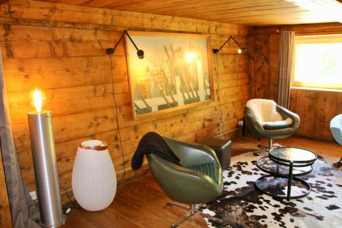 - un salon avec des murs en bois, des chaises et une bougie dans l'établissement Large Flat At The Foot Of The Slopes Les Houches, aux Houches