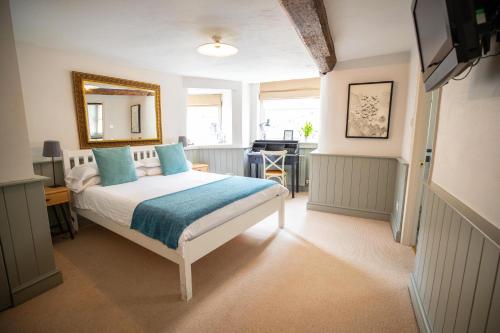 a bedroom with a bed with blue pillows and a mirror at Tower House Guest House in Oxford