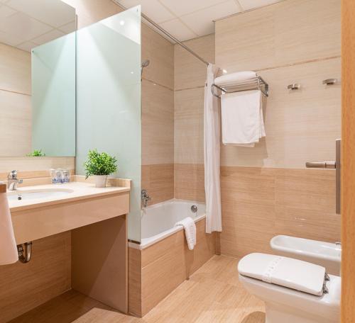uma casa de banho com um lavatório, uma banheira e um WC. em Hotel Alba em Puçol