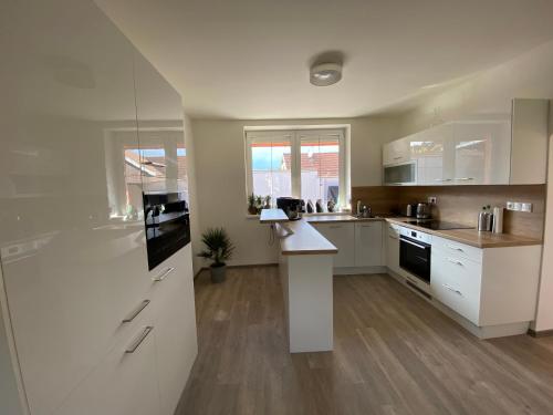 a kitchen with white cabinets and a counter top at Vila dům Emma in Bořetice