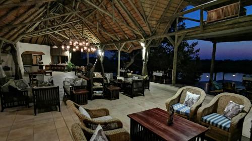 um pátio com cadeiras e uma mesa e um restaurante em Lianshulu Lodge em Kongola
